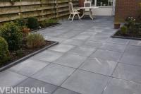 Bestrating van grote antraciet tuintegels