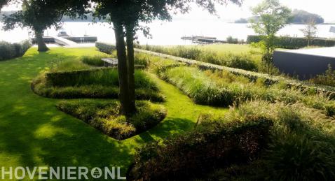 Landschappelijke tuin met siergras en gazon aan het water