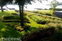 Landschappelijke tuin met siergras en gazon aan het water