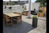 Achtertuin met sierbestrating en houten plantenbakken 1