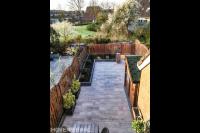 Bovenaanzicht achtertuin met siertegels en plantenbakken