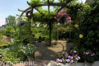 Houten pergola in kleurrijke groene tuin