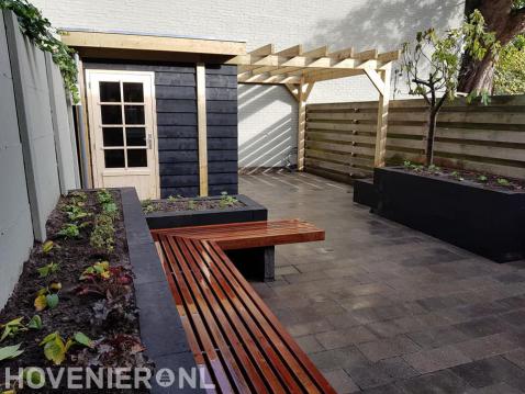 Achtertuin met houten schuurtje met pergola en maatwerk houten bankje