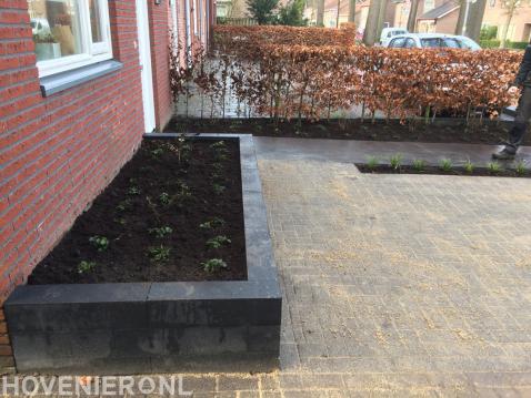 Voortuin met plantenbak en straatwerk van betonklinkers