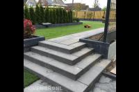 Stenen trappetje naar gazon met robotmaaier