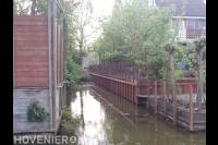 Houten beschoeiing en gaashekwerk bij tuin aan het water