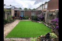 Achtertuin met kunstgras gazon