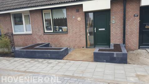 Kleine voortuin met plantenbakken