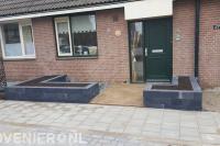 Kleine voortuin met plantenbakken