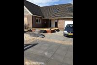 Oprit bestraten met combinatie van klinkers en grote tuintegels