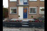 Onderhoudsvriendelijke voortuin met sierbestrating en plantenbakken