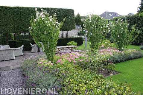 Tuin met strakke lijnen, veel groen en kleurrijke beplanting