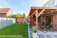 Tuinaanleg met graszoden en houten overkapping met vlonder