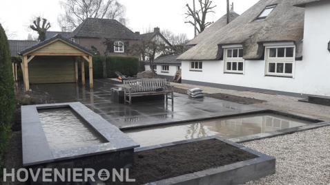 Tuinaanleg met vijver, bestrating en houten overkapping