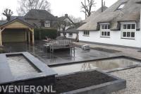 Tuinaanleg met vijver, bestrating en houten overkapping