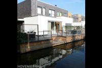 Tuin aan het water met vlonder, terras en hekwerk