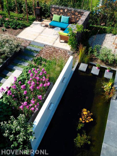 Strakke vijver met watermuur en stapstenen