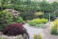 Tuin met kleurrijke beplanting en leibomen
