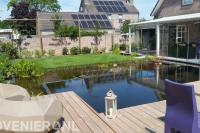 Achtertuin met terrasoverkapping, vijver en vlonderterras