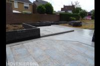 Bestrating van siertegels en plantenbakken van stapelblokken