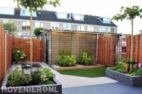 Strakke tuin met terras, gazon, plantenbakken en houten schutting 2