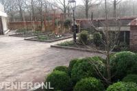 Tuin met houten pergola's en bestrating van waaltjes