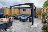 Achtertuin inclusief terras met overkapping en beton hout schutting