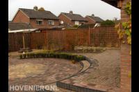 Achtertuin met hoogteverschil en straatwerk in cirkelpatroon