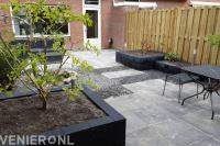 Achtertuin met plantenbakken en bestrating van natuursteen