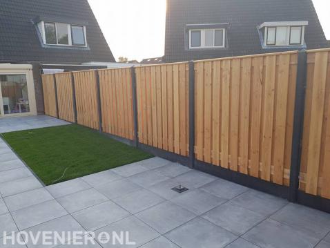 Tuinaanleg met betontegels, gras en hout beton schutting