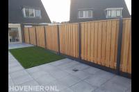 Tuinaanleg met betontegels, gras en hout beton schutting