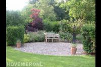 Bloemrijke tuin met verhoogde borders van Zweedse kasseien