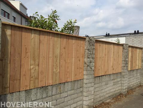 Gemetselde tuinafscheiding met houten panelen