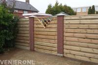 Houten schutting met gemetselde palen