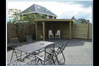 Houten overkapping en straatwerk van grote antraciet tegels