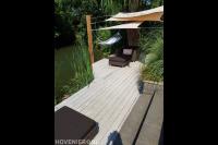 Vlonder met zonnedoek en hangmat aan het water