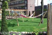 Gemeenschappelijke tuin met beschut terras en gazon met hangmatten