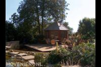 Zithoek met prieel bij vijver