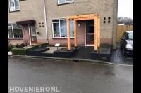 Onderhoudsvriendelijke voortuin met grind, plantenbakken en pergola