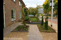 Voortuin met sierbestrating en plantenbakken