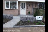Onderhoudsarme voortuin met grote tegels en schanskorven 1