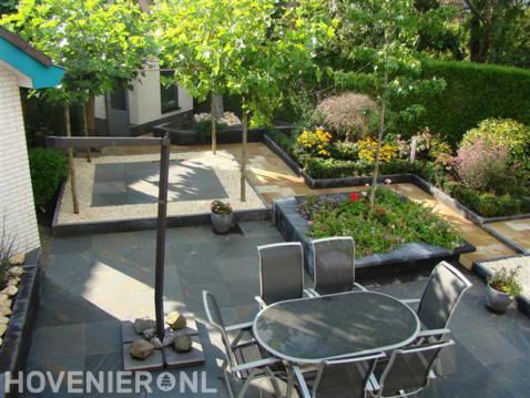 Compacte tuin met terras en borders met kleurrijke beplanting