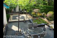 Compacte tuin met terras en borders met kleurrijke beplanting