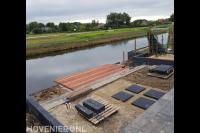 Tuinaanleg met bestrating en houten vlonder aan het water