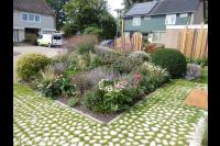 Kleurrijke border en bijzondere verharding van keien met gras