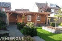 Tuin met strakke lijnen en houten schuur met overkapping