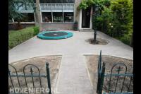 Voortuin met straatwerk van klinkers en trampoline