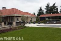 Ruime villatuin met terras, vlonder en gazon bij zwembad