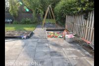 Kindvriendelijke achtertuin met bestrating, gazon en schommel