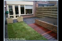 Achtertuin met klein terras en gazon, vlonder en verhoogde bloembak